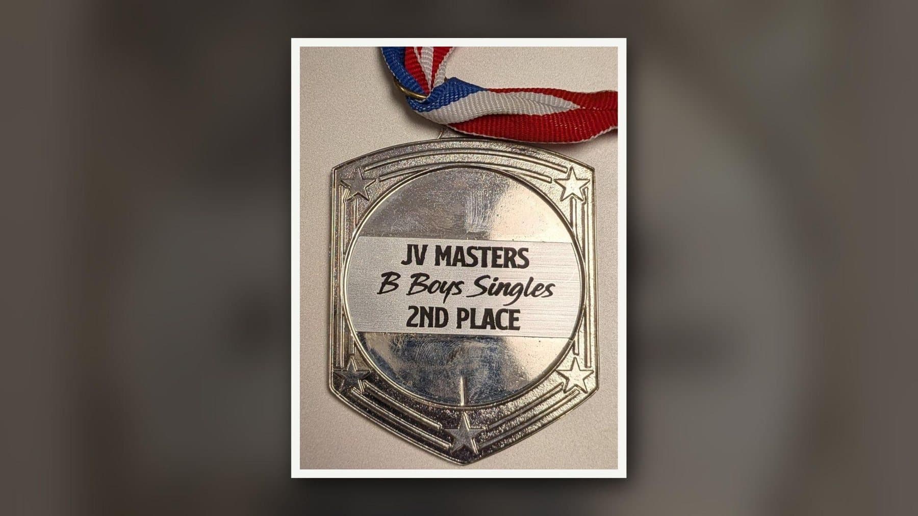刻有「JV Masters B Boys Singles 2nd Place」的網球獎牌。